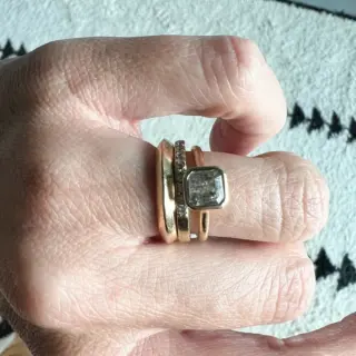 Close‑up of 1.15 ct salt and pepper Asscher‑cut diamond bezel‑set east‑west on a 1.6 mm soft knife‑edge band in 14 kt recycled yellow gold