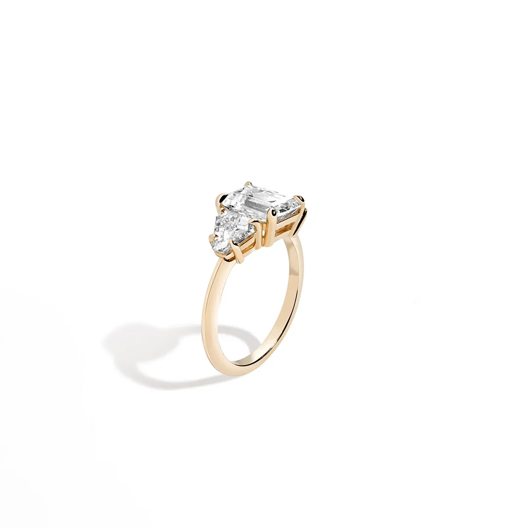 Close‑up of 3‑Stone Emerald + Triangle Ring showcasing emerald‑cut diamond flanked by two triangle side stones.