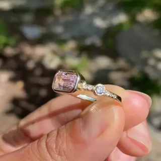 Side view of Hikaru Ring No. 10 showing emerald-cut pink sapphire and flush-set champagne diamonds on square recycled gold band