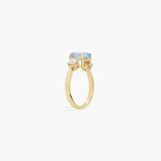 Elegant yellow gold ring featuring oval aquamarine and prong-set round diamonds on either side
