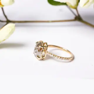 Front view of Melissa Tyson Designs' Destiny engagement ring, showcasing a 3.17ct oval double-cut salt and pepper diamond with red inclusions, set in a hammered halo basket.