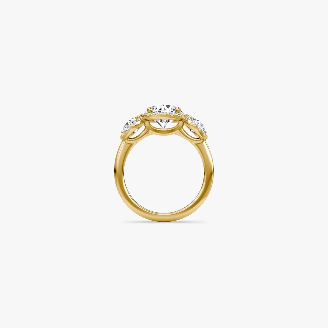 Three‑Stone Halo Ring by VRAI in 18K yellow gold with round brilliant center diamond and trapezoid side stones with pavé halo