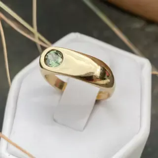 The Indigo Emerald Ring worn on hand, illustrating its bold design and the radiant emerald-cut center stone set in 14k gold.