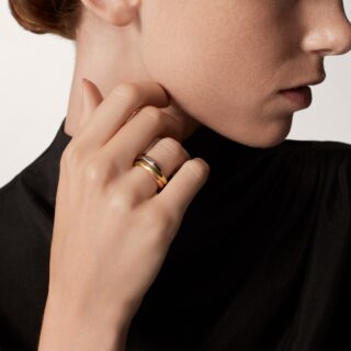 Close-up of Cartier Trinity 5‑diamond ring showing the delicate bezel‑set diamonds across the white gold band.