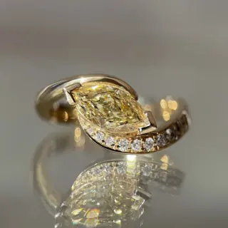Close-up of 1.15ct yellow diamond marquise ring with demi pavé setting in 14k gold