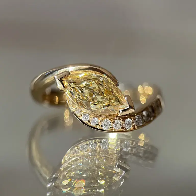 Close-up of 1.15ct yellow diamond marquise ring with demi pavé setting in 14k gold