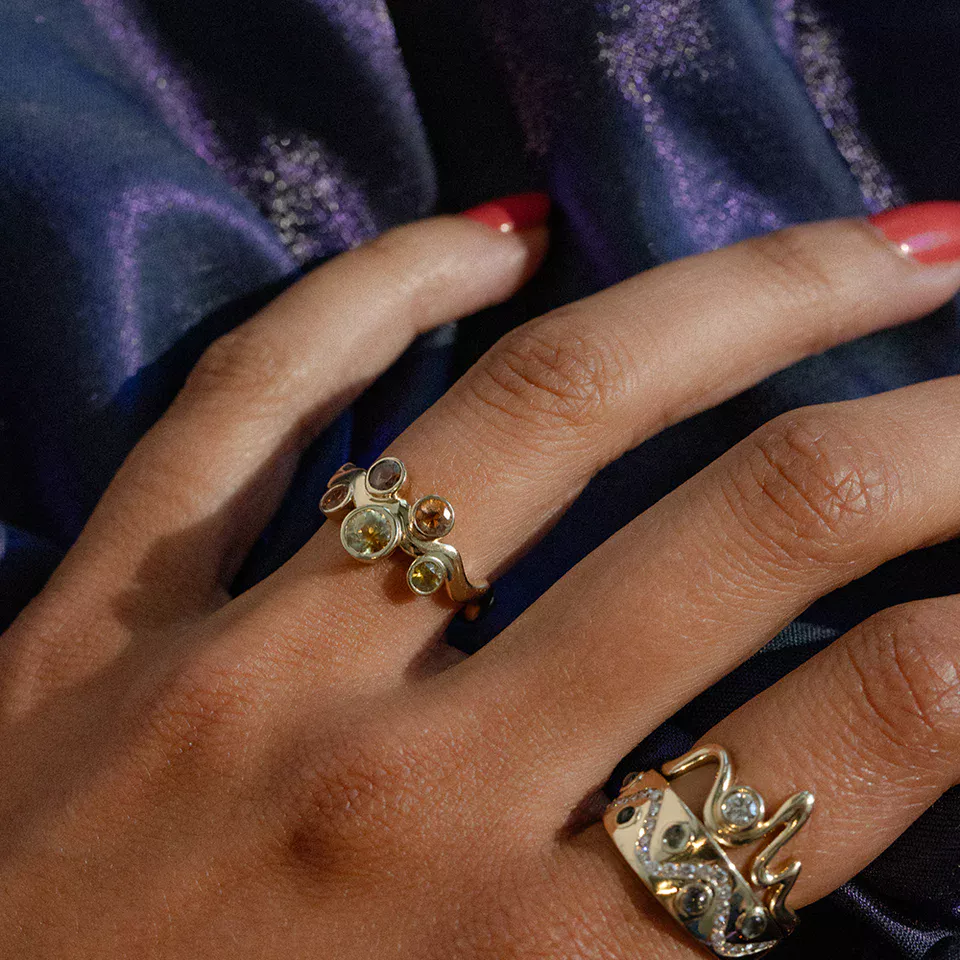 Macro detail of the Cadlina ring’s sapphires, revealing the kaleidoscope effect and grain of the yellow-gold setting.