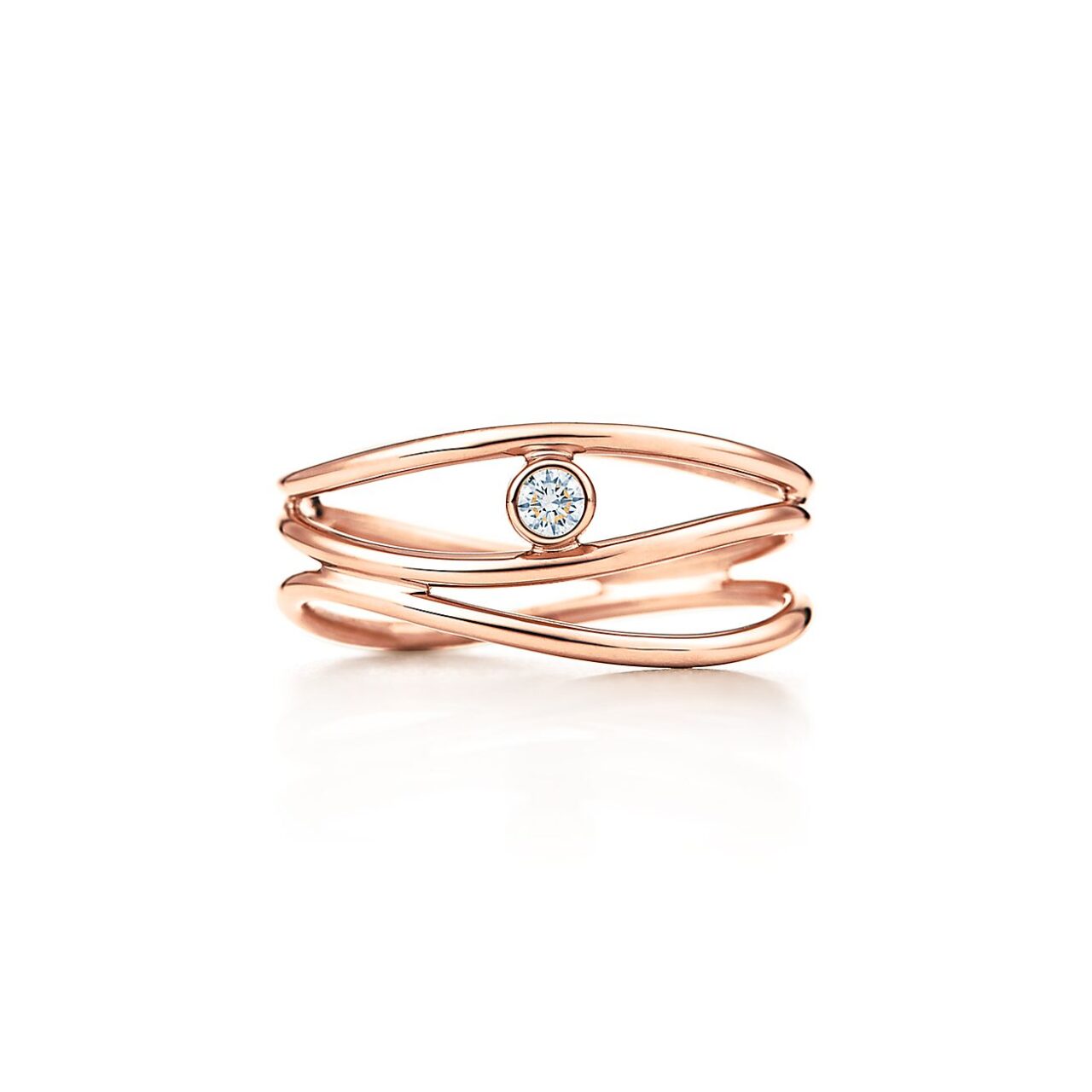 Close‑up of Elsa Peretti Wave ring in 18 kt rose gold, showing undulating triple bands cradling a small round brilliant diamond.