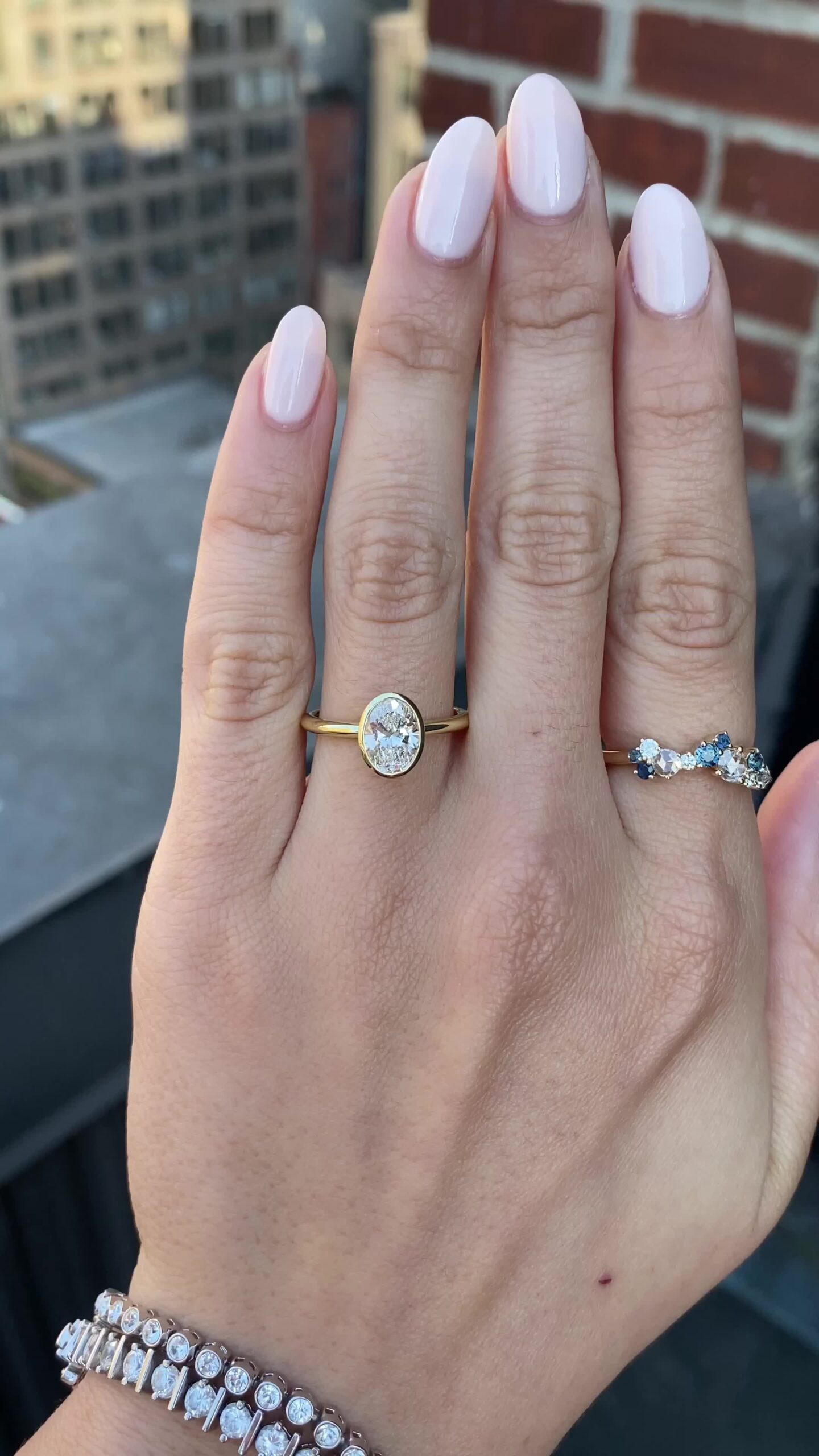 Elegant engagement ring featuring an oval diamond encircled by a contoured bezel for a modern minimalist look.