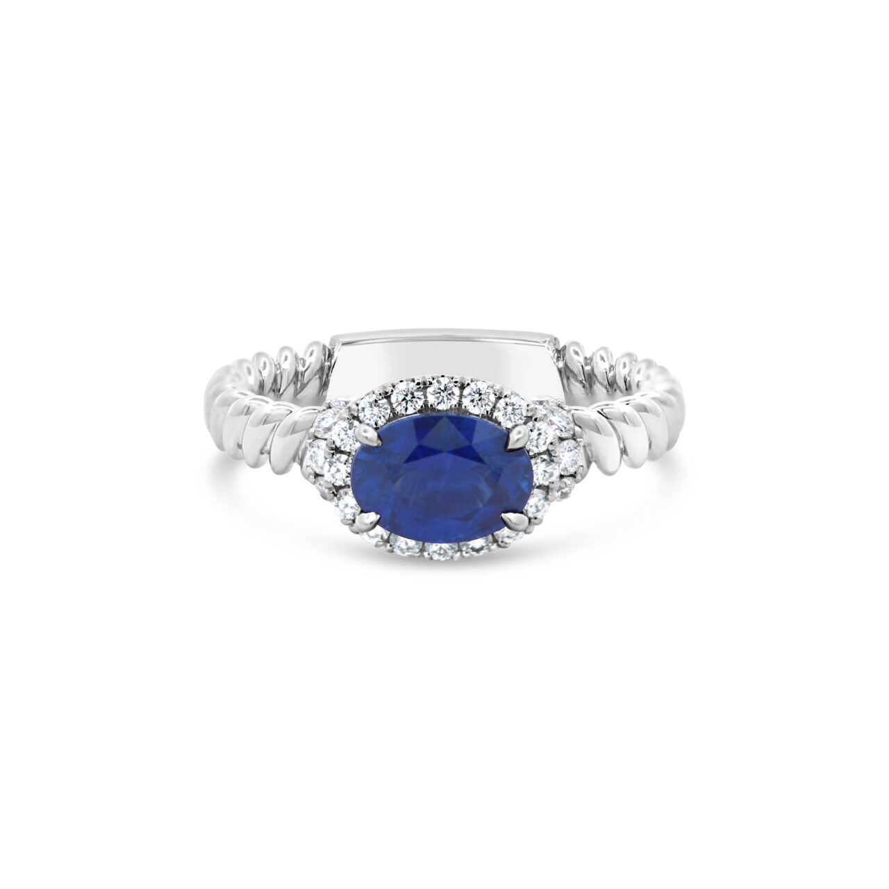 Jack Kelege KGR170S Oval Sapphire and Diamond Ring featuring 1.28ct east-west set oval sapphire and 0.32ct G VS diamonds in 18k white gold.