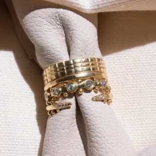 Model wearing the Koemi 5‑Stone white diamond ring in recycled 14k gold by M. Hisae, showing delicate sparkle from five reclaimed diamonds and the rhythmic gold bead pattern.