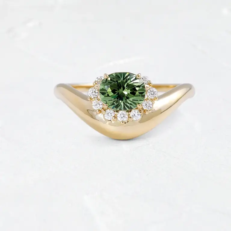 Close-up of the Astronomer Ring with a 1 ct mint green demantoid garnet encircled by nine white diamonds, set in 14k yellow gold