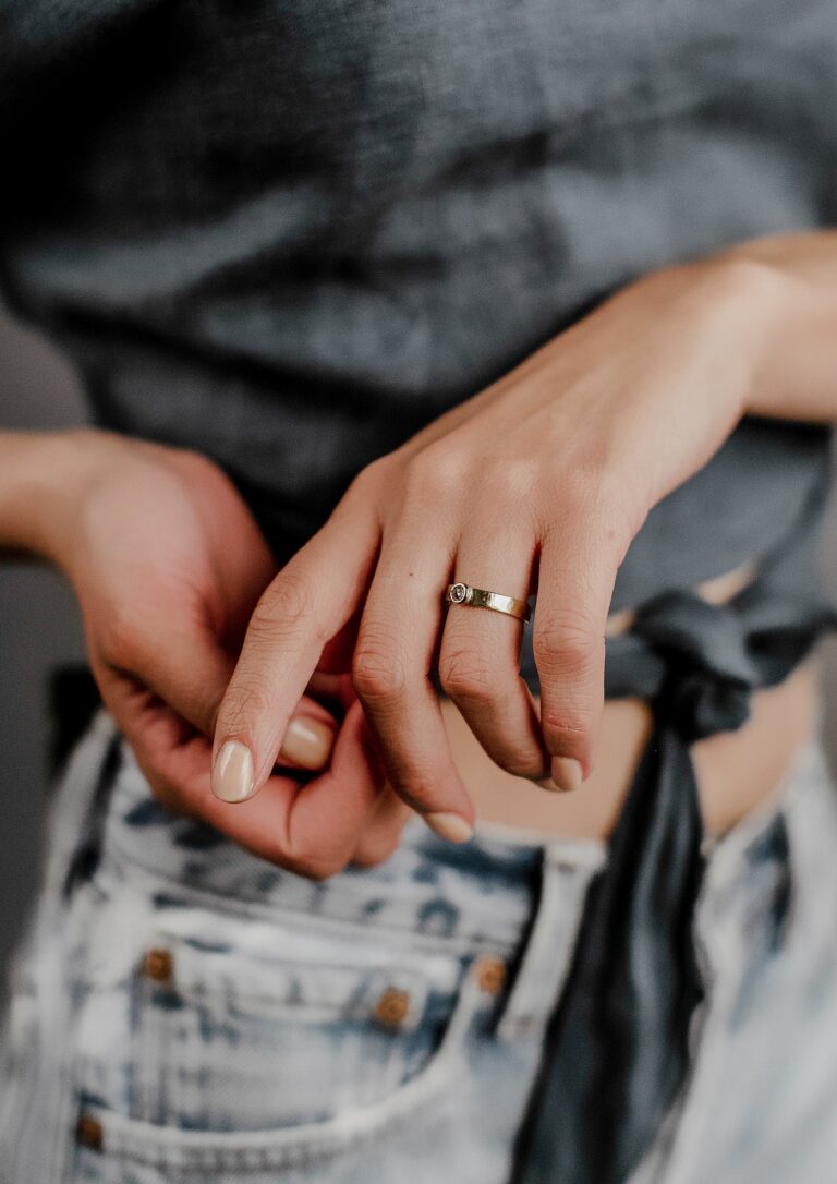 Close-up of Natalie Diamond Solitaire Ring showcasing a 3.4mm round rose-cut white diamond set in a 4mm wide hammered 14k yellow gold band.