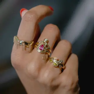 Wavy arrangement of Montana sapphires in the Cadlina ring, set in a slim 14K yellow-gold band, shown at an angle to highlight depth and color variation.