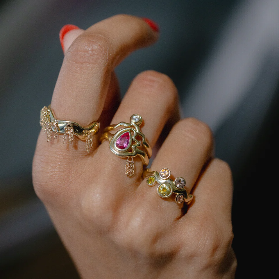 Wavy arrangement of Montana sapphires in the Cadlina ring, set in a slim 14K yellow-gold band, shown at an angle to highlight depth and color variation.