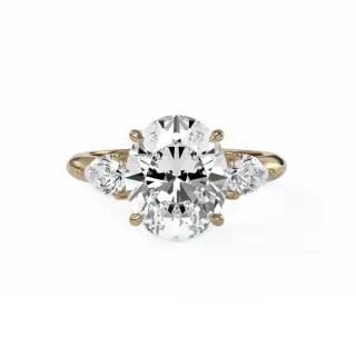 Three-stone engagement ring with oval center diamond and pear-shaped side stones in 14k yellow gold