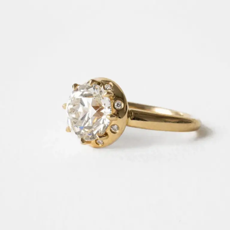 Close-up of the Arden Euro Cut ring featuring a 3 ct vintage‑style Euro‑cut round center stone with a chunky halo of flush‑set round accents in 14k gold.