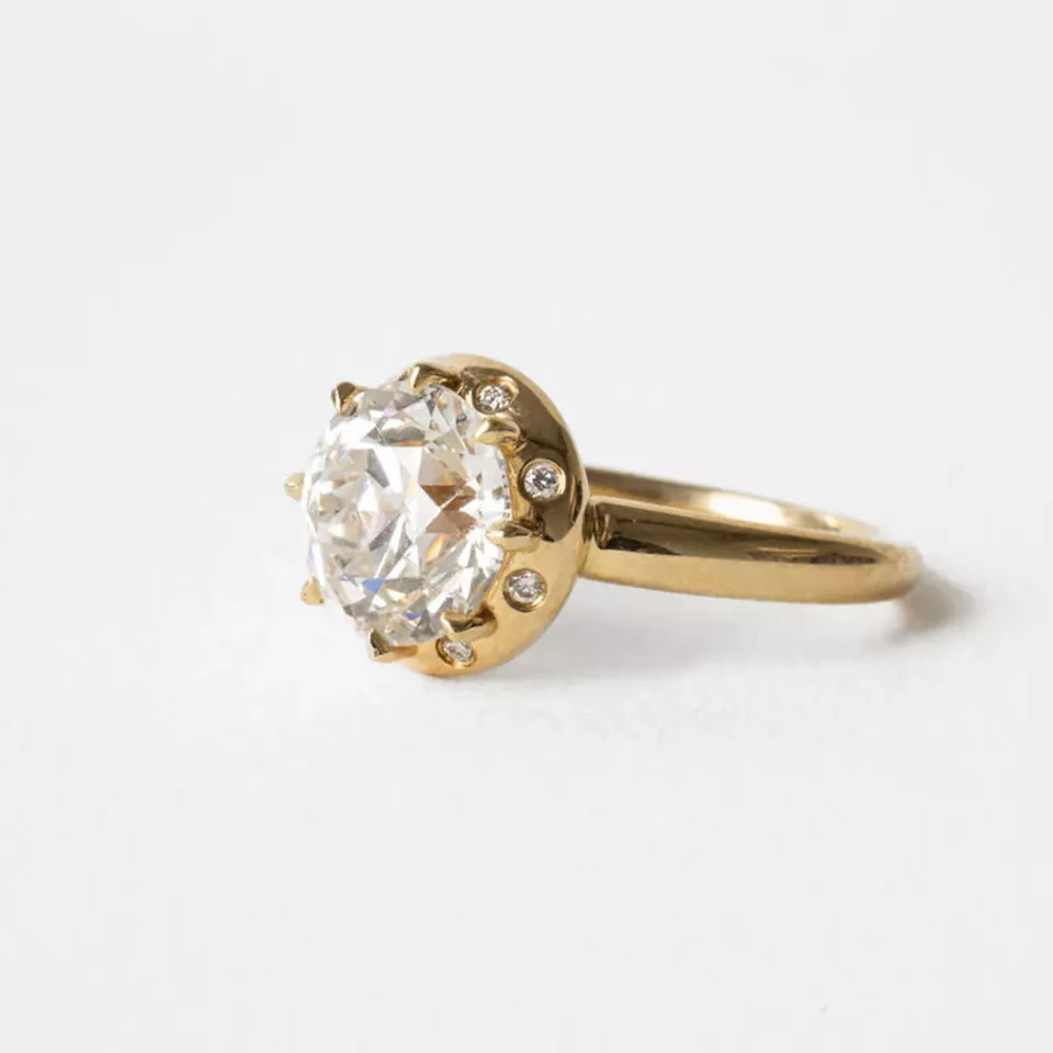 Close-up of the Arden Euro Cut ring featuring a 3 ct vintage‑style Euro‑cut round center stone with a chunky halo of flush‑set round accents in 14k gold.