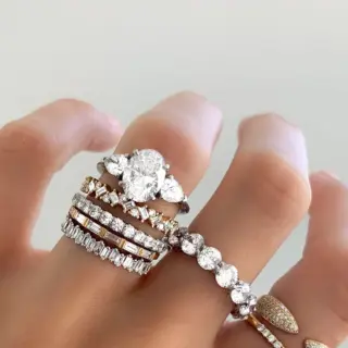 Elegant yellow gold engagement ring featuring an oval-cut diamond flanked by pear-shaped diamonds