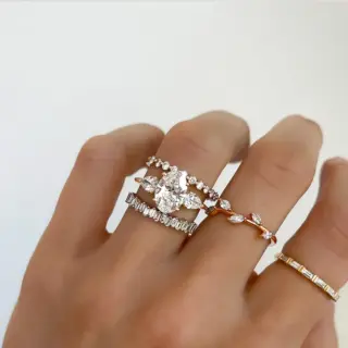 Oval cut diamond engagement ring with pear-shaped side stones set in yellow gold