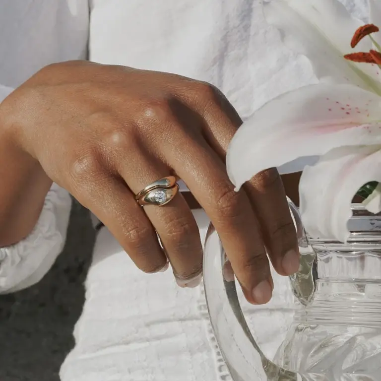 Close-up of Emmeline gray diamond engagement set—5 mm round diamond in bezel, sculptural gold band