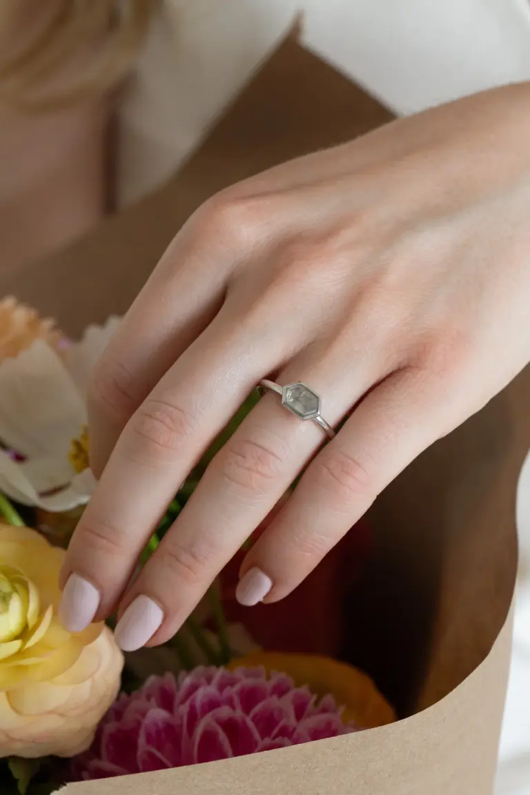 Close-up of 14 k white gold bezel ring featuring a 1.21 ct hexagon rustic diamond oriented east‑wes