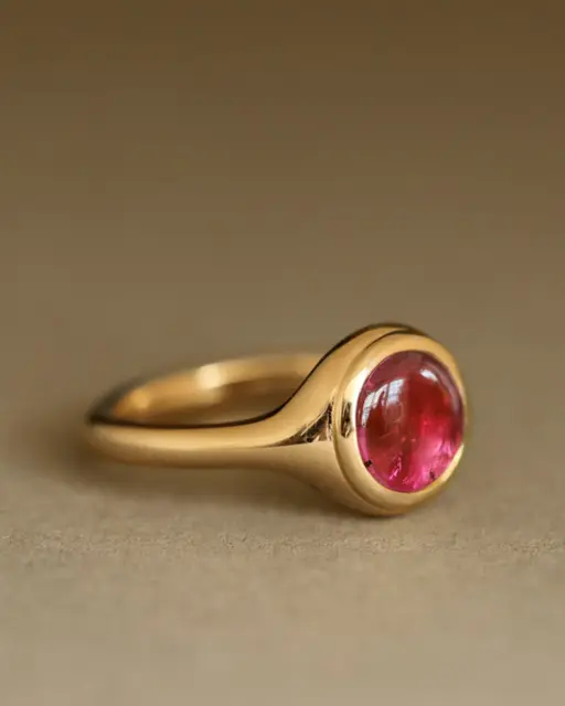 Close-up of The Duchess Ring featuring a 7mm rubellite pink tourmaline cabochon set in solid 18K yellow gold.