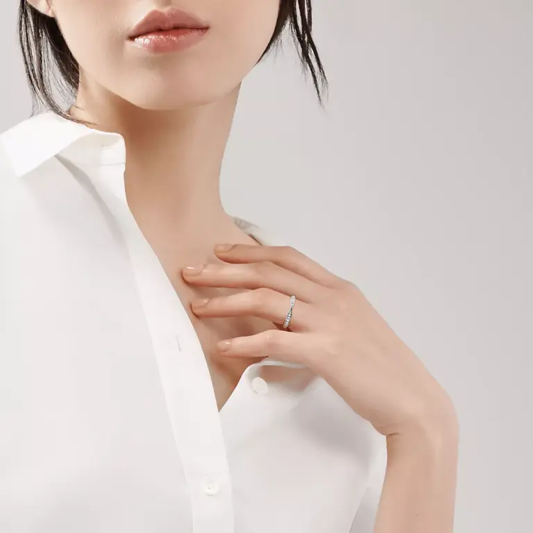 Close-up of Tiffany Harmony® platinum band ring showing bead-set round brilliant diamonds on a gently tapered 1.8 mm band