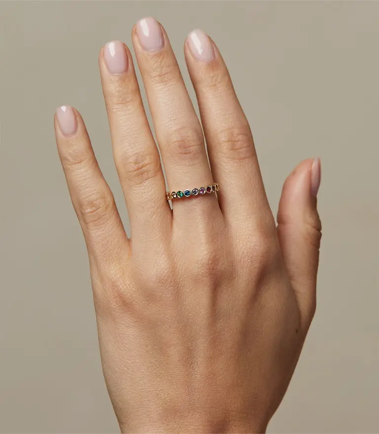 Colorful eternity ring with seven rainbow gemstones bezel‑set in yellow, white, or rose gold—Aura by Sofia Kaman